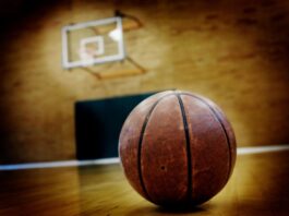 Basketball auf dunklem Spielfeld als Symbol für den NBA-Skandal um Pokerbetrug und Insiderwetten