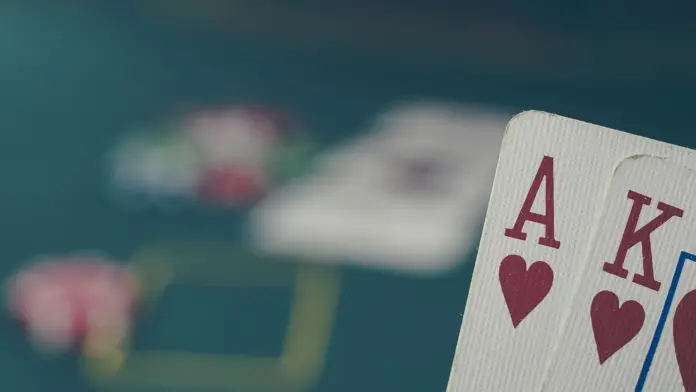 420084-entries-das-ocean-ko-uebertrifft-pokerstars Ein Herz-Ass und ein Herz-König auf einem Pokertisch mit unscharfen Chips im Hintergrund.