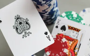 „92“ führt die neun Überlebenden in Rozvadov an Pokerchips und Spielkarten, darunter ein Pik-Ass, auf einem grauen Tisch