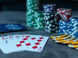 Pokerkarten und Stapel von Pokerchips auf einem Tisch
