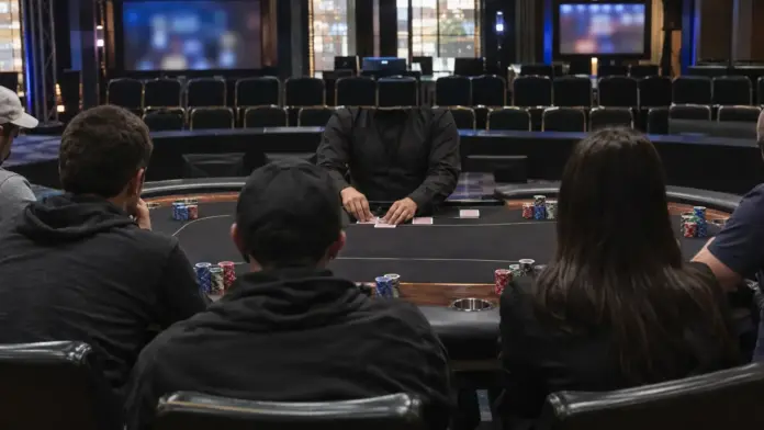 event-5-10500-dollar-block-poker-masters Vorbereitetes Pokerturnier im Studio mit Spielern, Dealer, Karten und Chipstapeln an einem Tisch