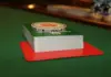 Jágr führt das Finale der German Poker Days an Ein Stapel Spielkarten mit einem Dealer-Button auf einem grünen Pokertisch