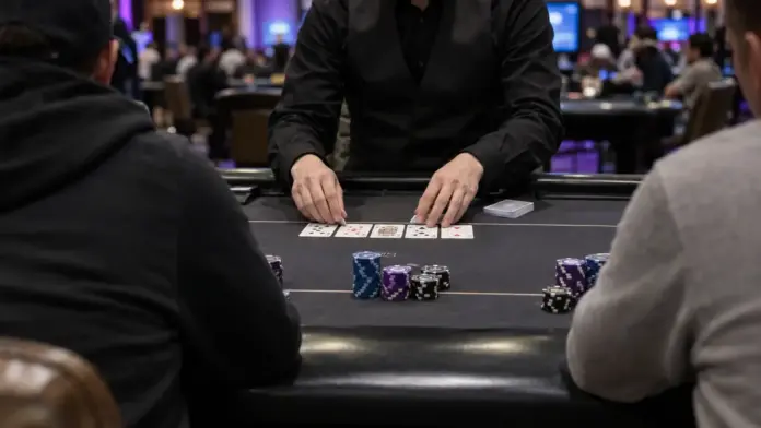 palma-fuehrt-nach-event-4-bei-poker-masters Finaltisch eines Pokerturniers mit Dealer, Karten und Chipstapeln in Las Vegas