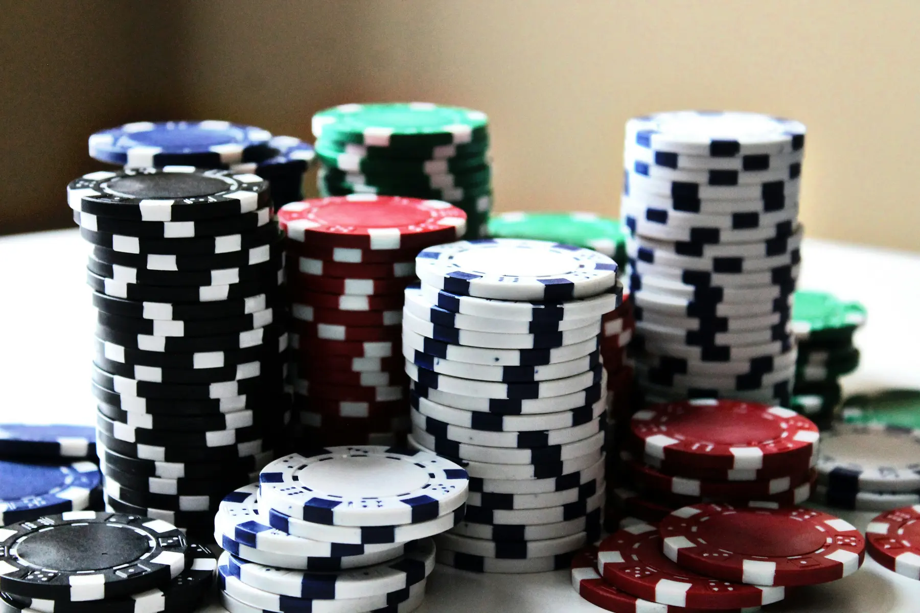 Mehrere Stapel bunter Pokerchips auf einer weißen Oberfläche