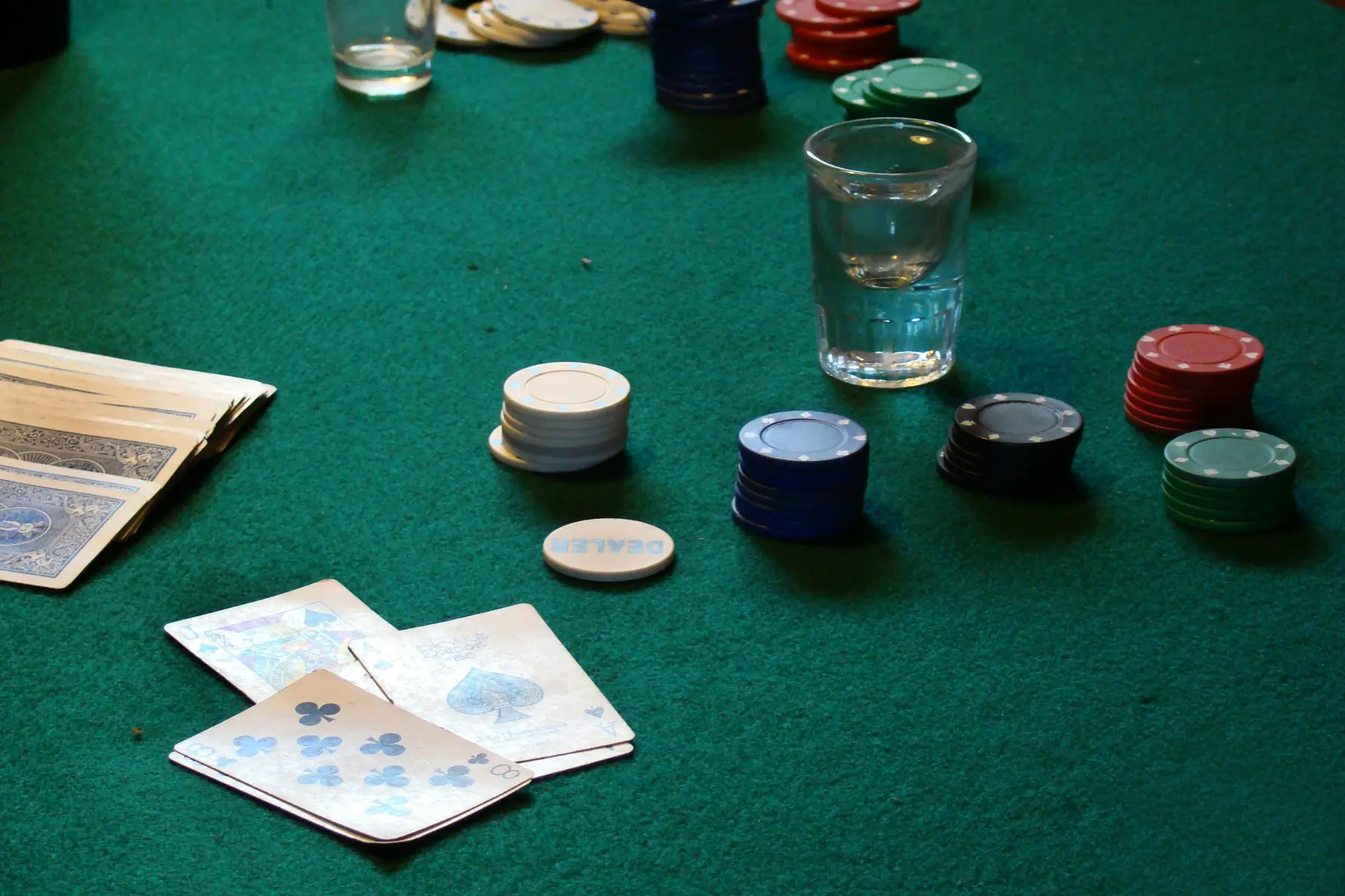 Pokerchips und Spielkarten auf einem grünen Filztisch
