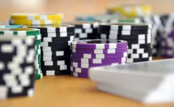15.779 Entries und €35,8 Mio.: Prags WSOPE-Premiere Nahaufnahmen von Pokerchips und Spielkarten auf einem Holztisch.