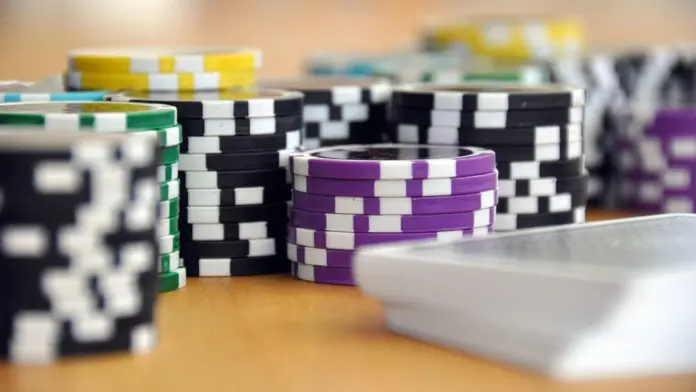 prags-wsope-premiere Nahaufnahmen von Pokerchips und Spielkarten auf einem Holztisch.