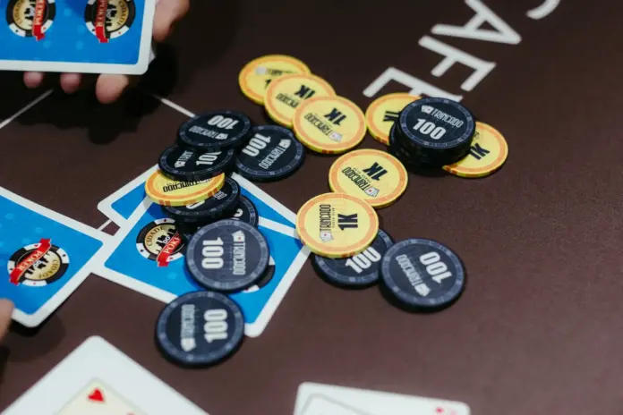 Pokerchips und Spielkarten auf einem Turniertisch während einer Texas-Hold’em-Hand Pokerchips und Spielkarten auf einem Turniertisch während einer Texas-Hold’em-Hand