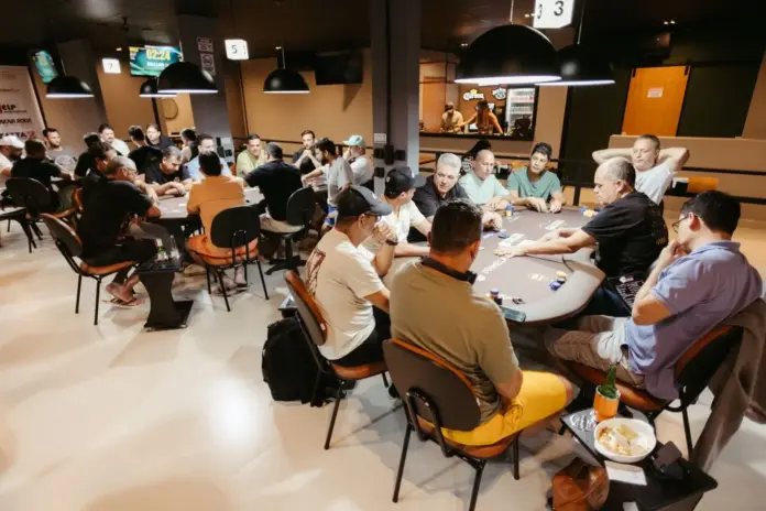 Pokerspieler an mehreren Tischen während eines Live-Turniers in einem Pokerraum Pokerspieler an mehreren Tischen während eines Live-Turniers in einem Pokerraum