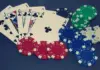 Stepanyan startet als Chipleader in die German Poker Days Pokerkarten mit einem Royal Flush in Treff und verschiedene farbige Pokerchips auf dunklem Hintergrund