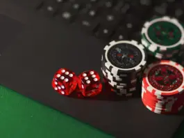 Pokerchips und rote Würfel auf einem Laptop
